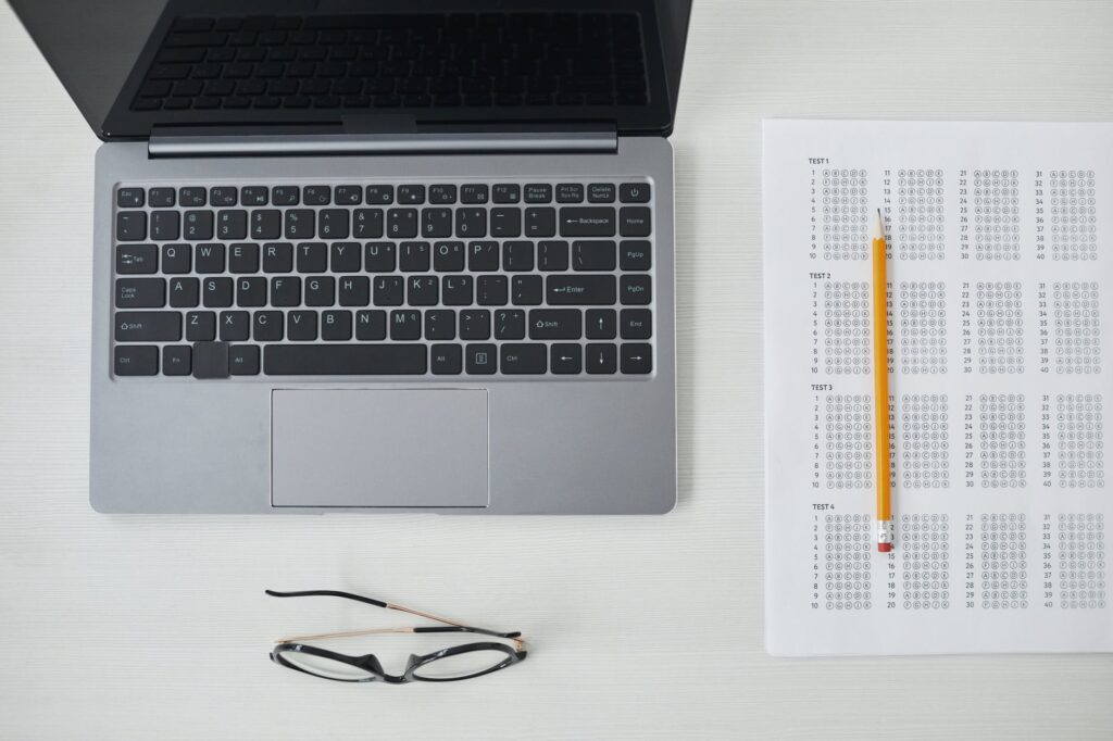 a top view of laptop and test paper on the table